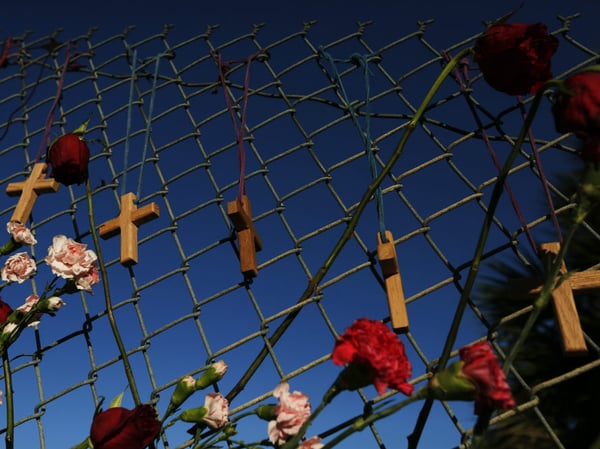 Crosses and flowers hang on a fence near Marjory Stoneman Douglas High School in Parkland, Fla., on Saturday, Feb. 16, 2018, in memory of the 17 people killed in a school shooting there.